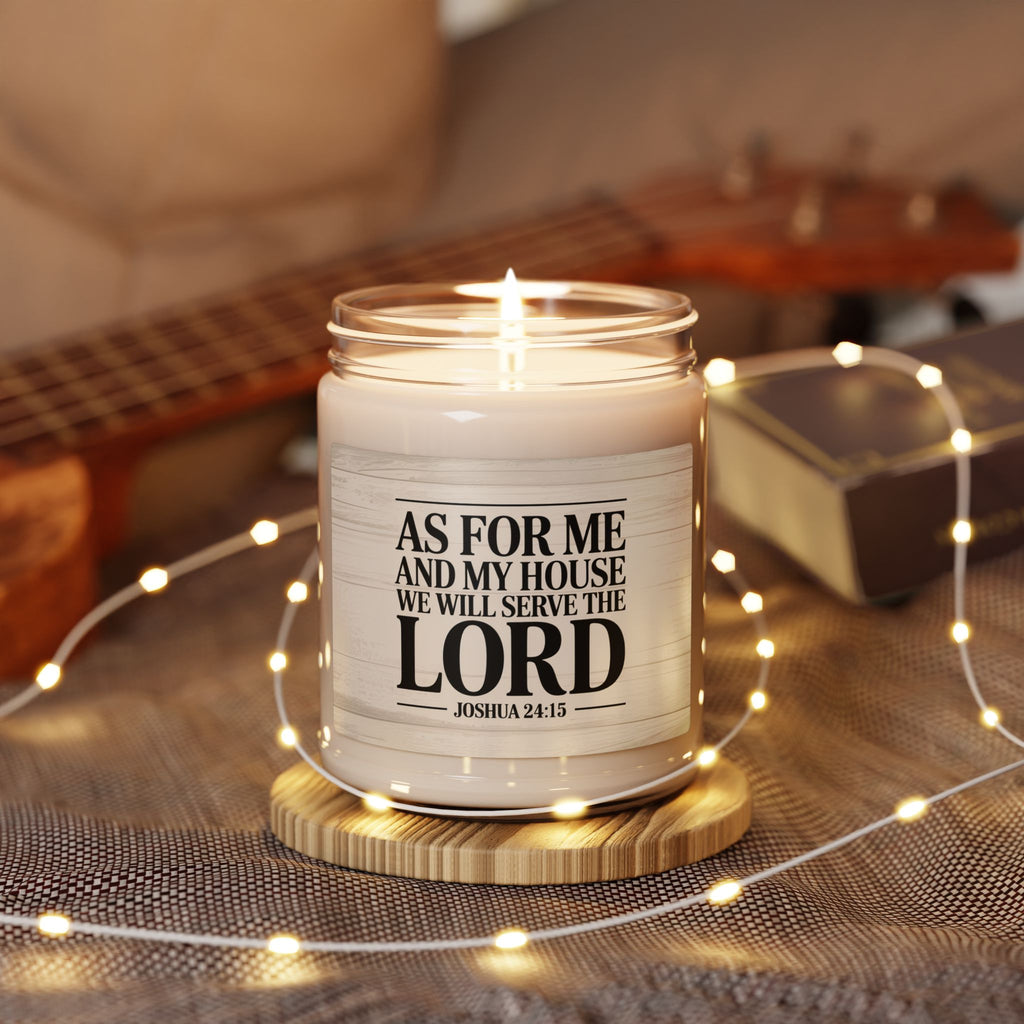 Candle with a religious message on a wooden coaster surrounded by string lights and a guitar in the background.