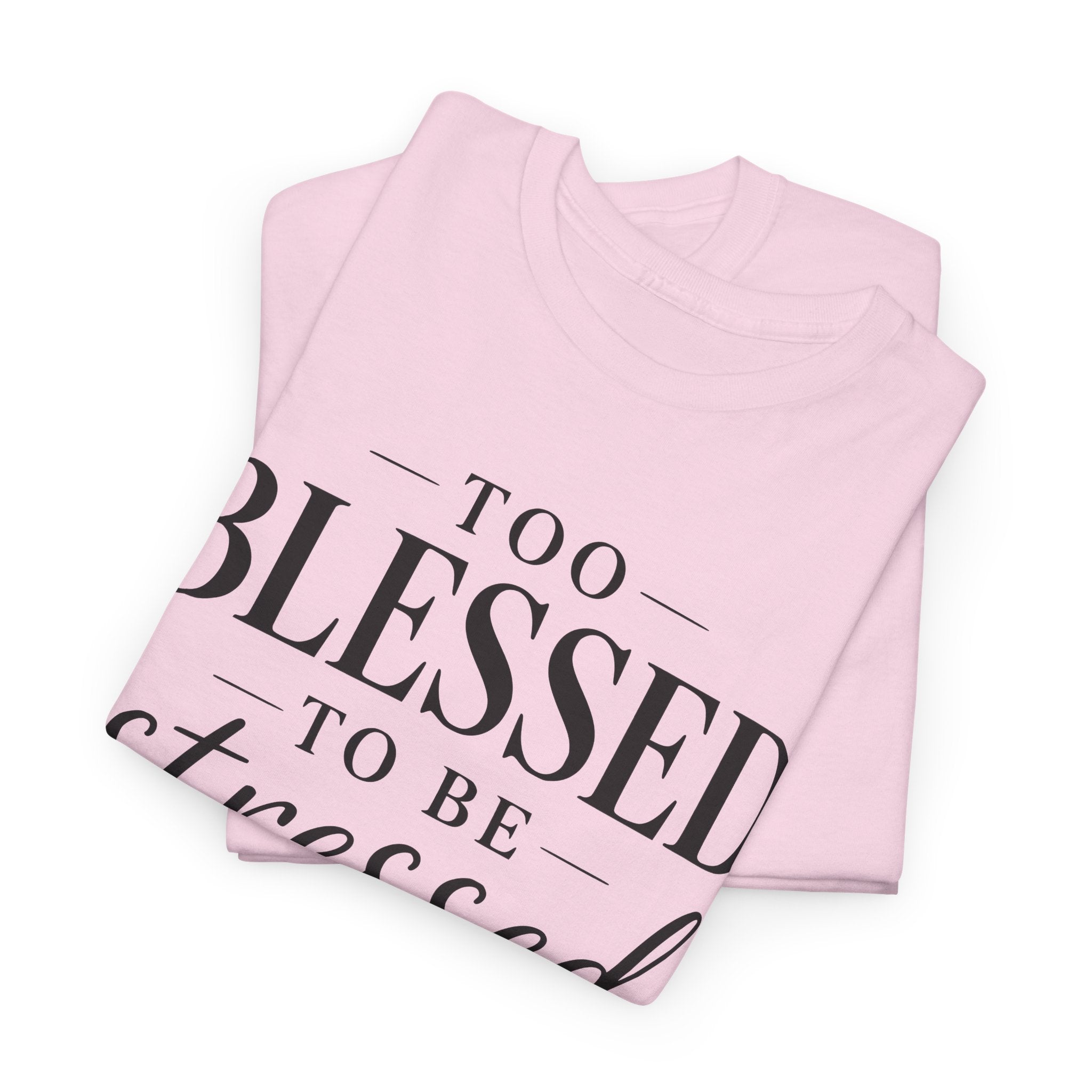 Folded pink t-shirt with 'Too Blessed To Be Stressed' text on a white background