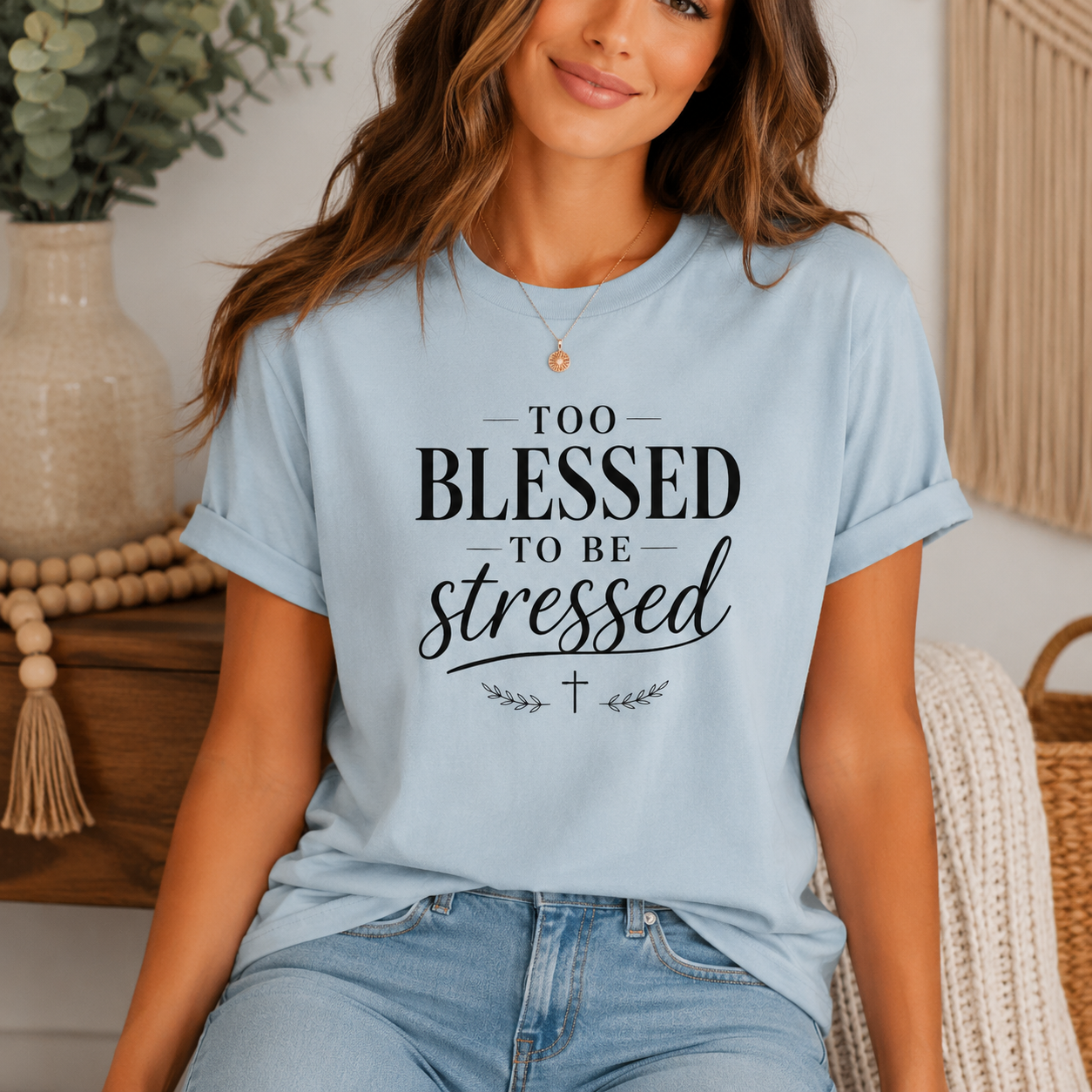 Woman wearing a light blue t-shirt with 'Too Blessed to be Stressed' text in a home setting.