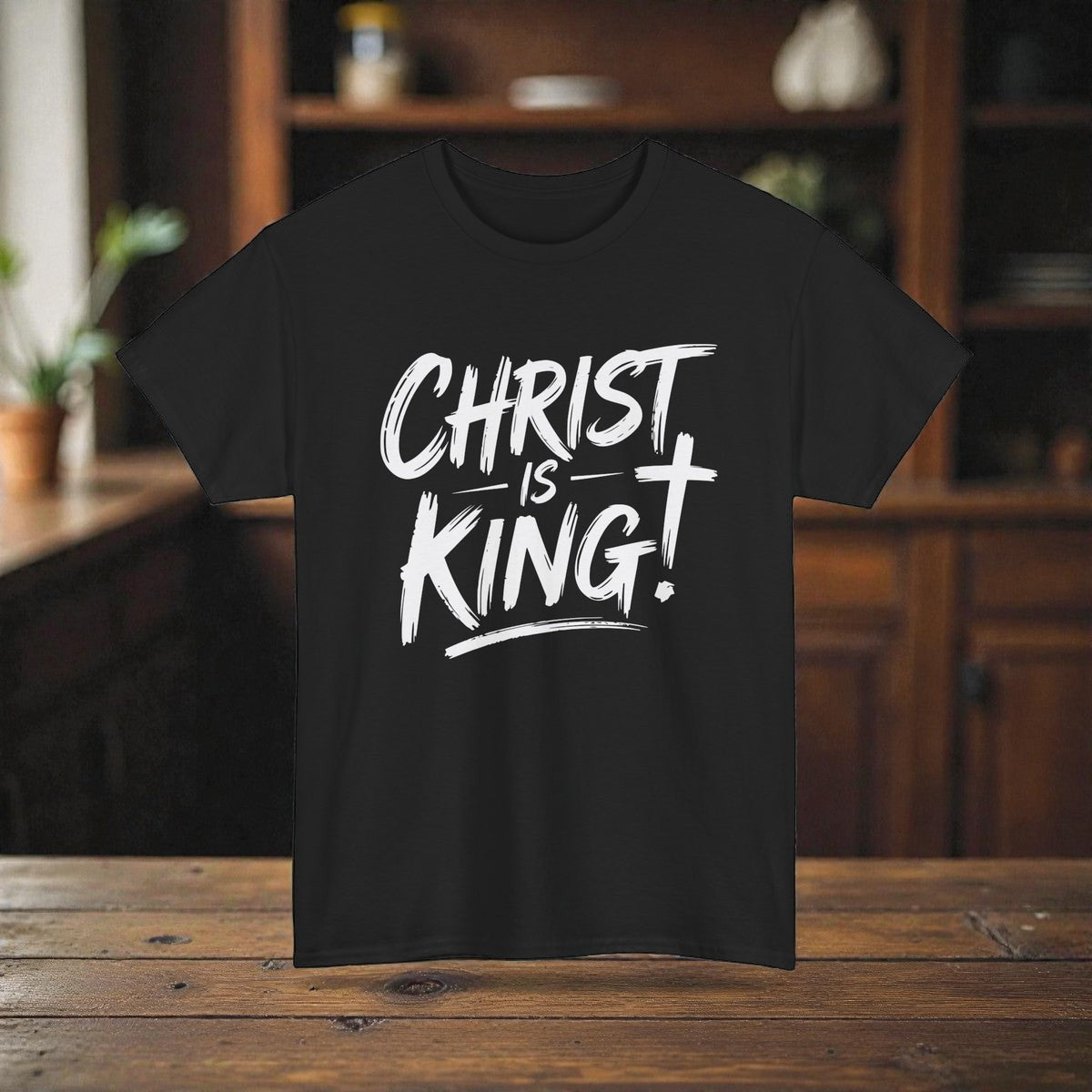 Black t-shirt with 'Christ is King!' text on a wooden surface